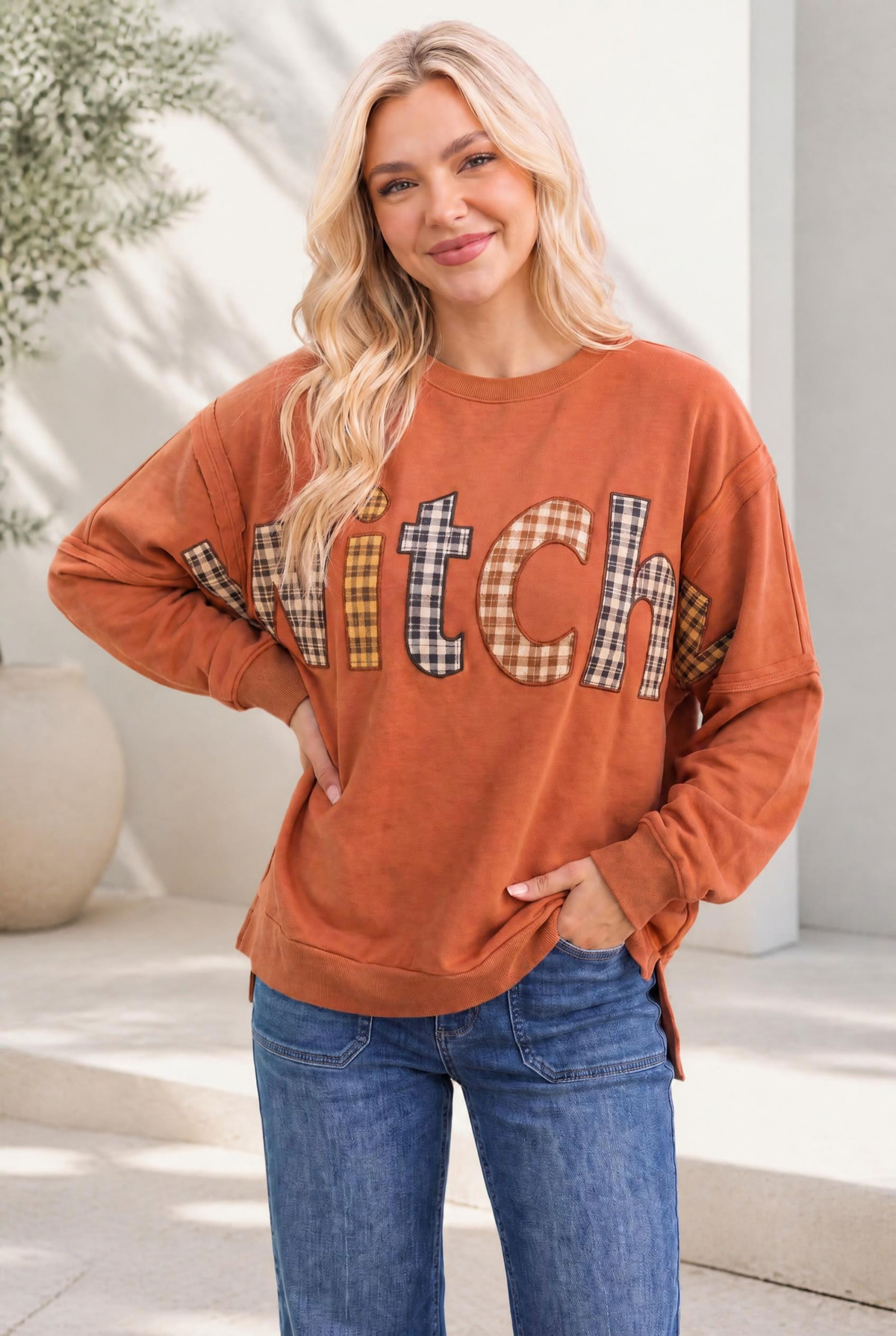 Rust-colored sweatshirt with plaid patchwork lettering, oversized fit, ribbed cuffs and neckline