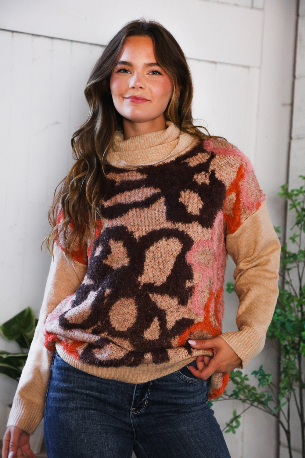 Woman wearing a floral patterned sweater with a neutral background