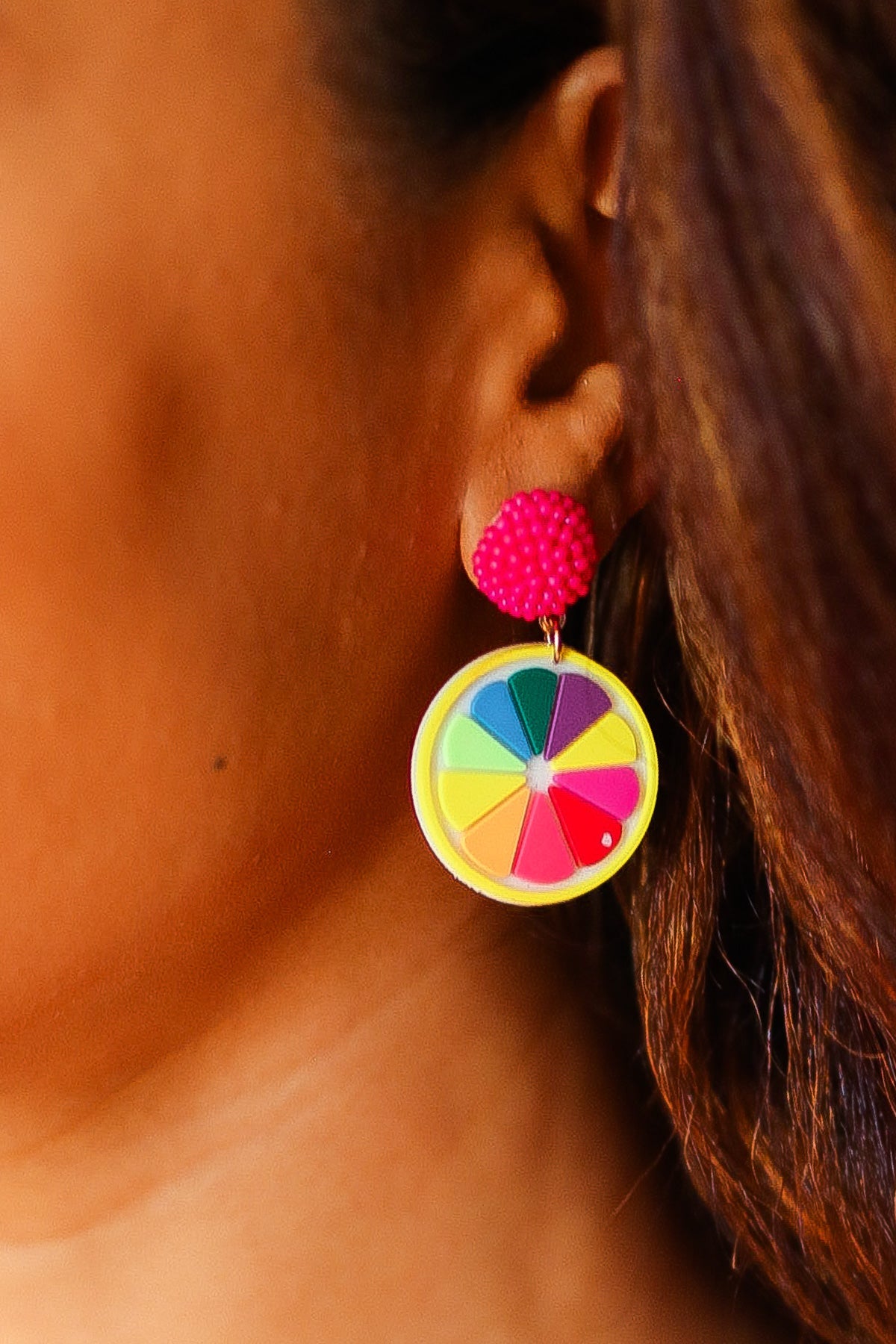 Close-up of a colorful wheel earring worn by a woman