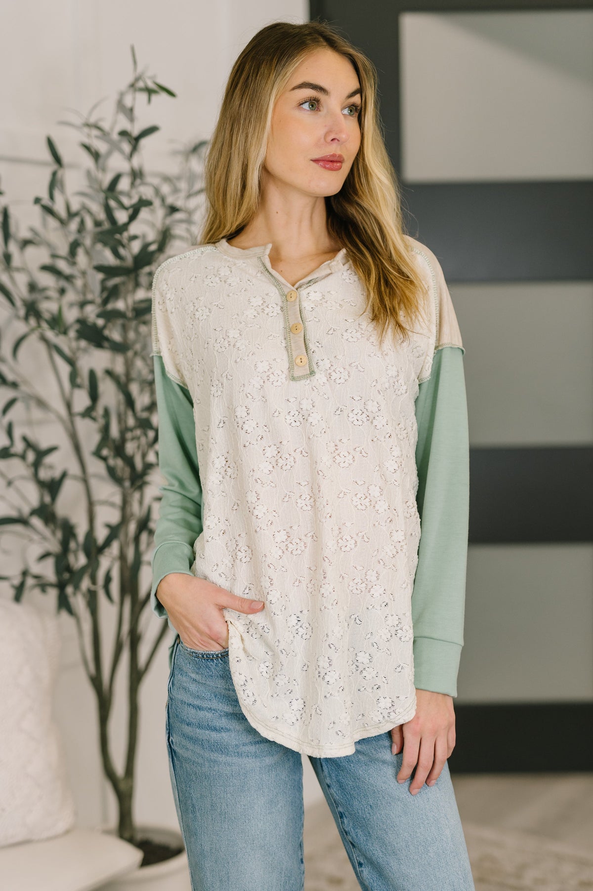 Drop shoulder henley top with lace overlay, banded cuffs, and scooped hem.