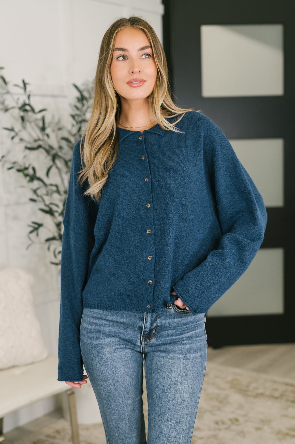 Model wearing a midnight blue button-down shirt with drop shoulders and rolled sleeve cuffs.