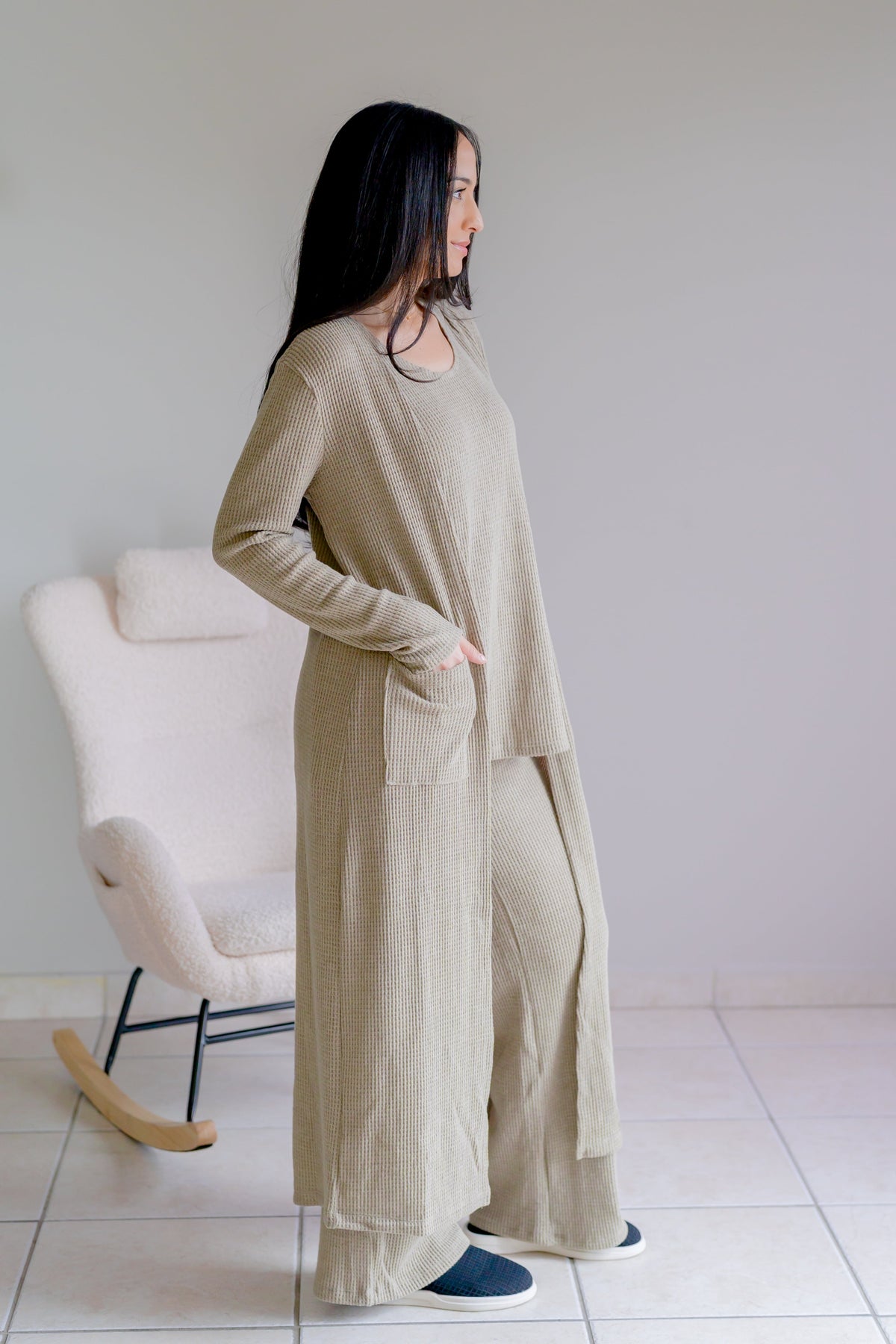 Woman wearing a light olive three-piece set with a tank, long cardigan, and wide-leg pants.