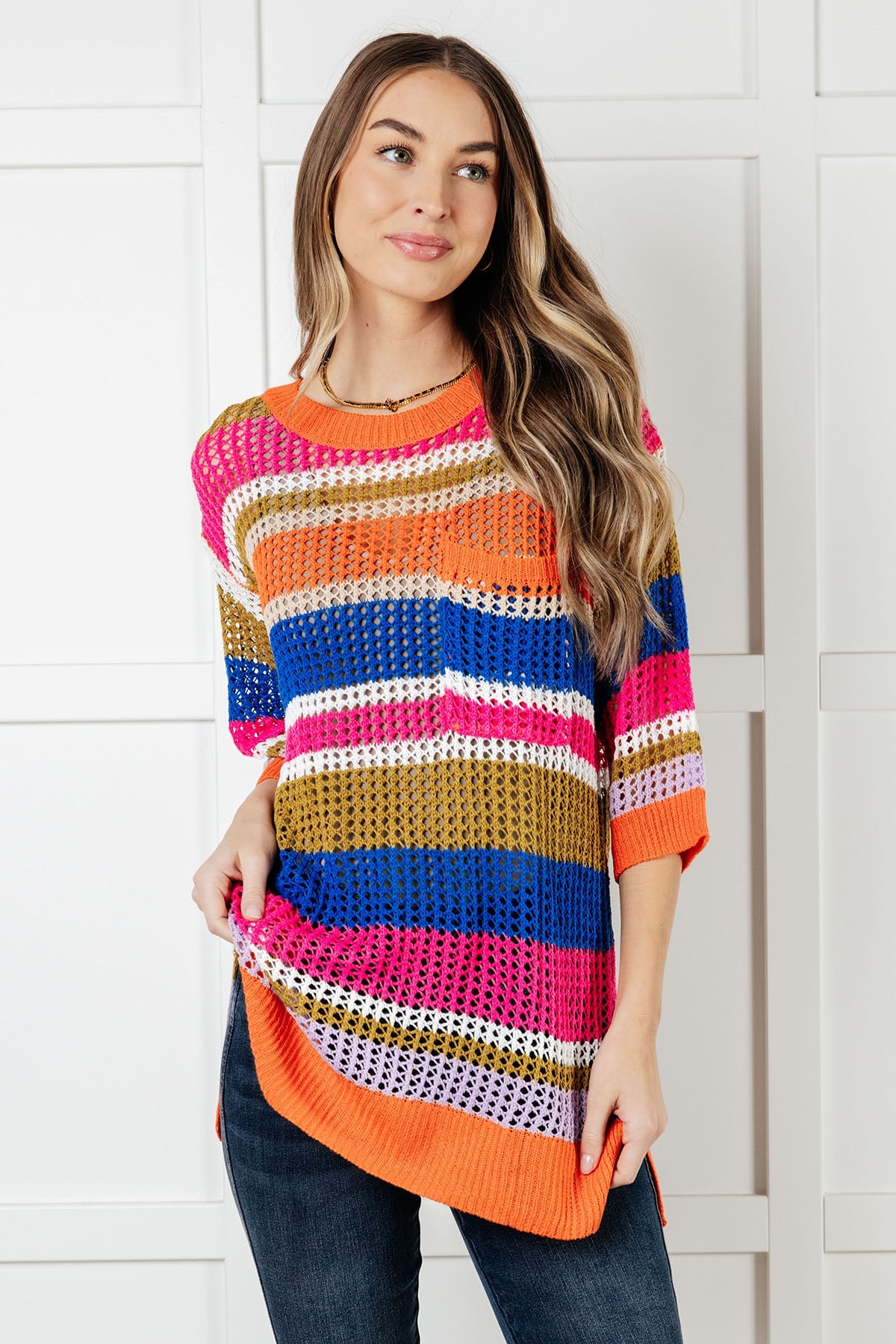 Woman wearing a colorful striped sweater against a white background