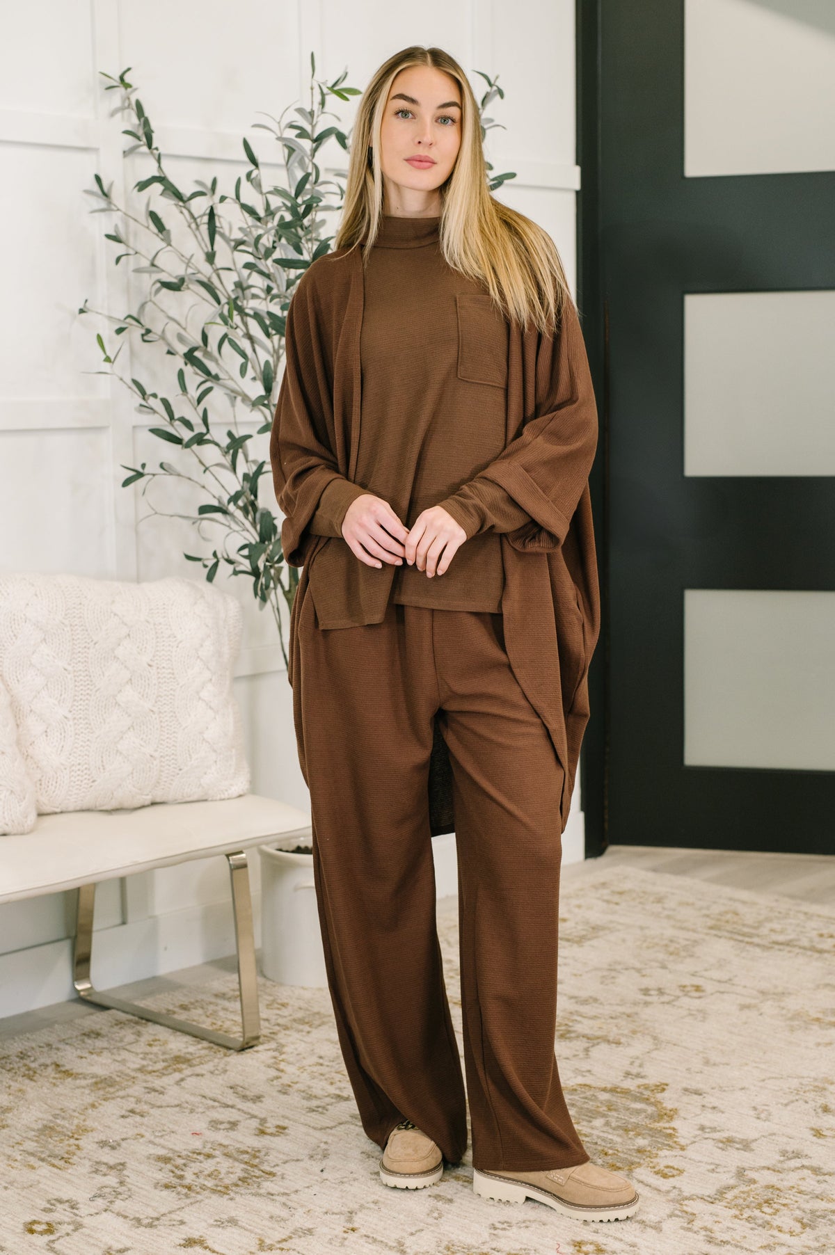 A model wearing a dark mocha two-piece set with a waffle knit cardigan and wide-leg pants.