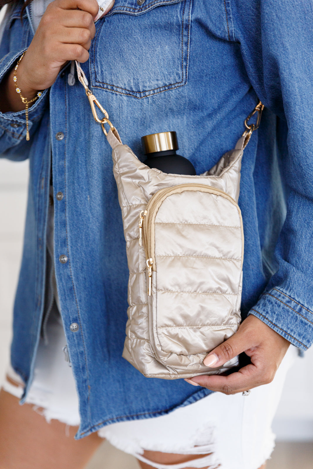 Gold puffer tote with zipper pocket and adjustable strap, shown with a water bottle inside.