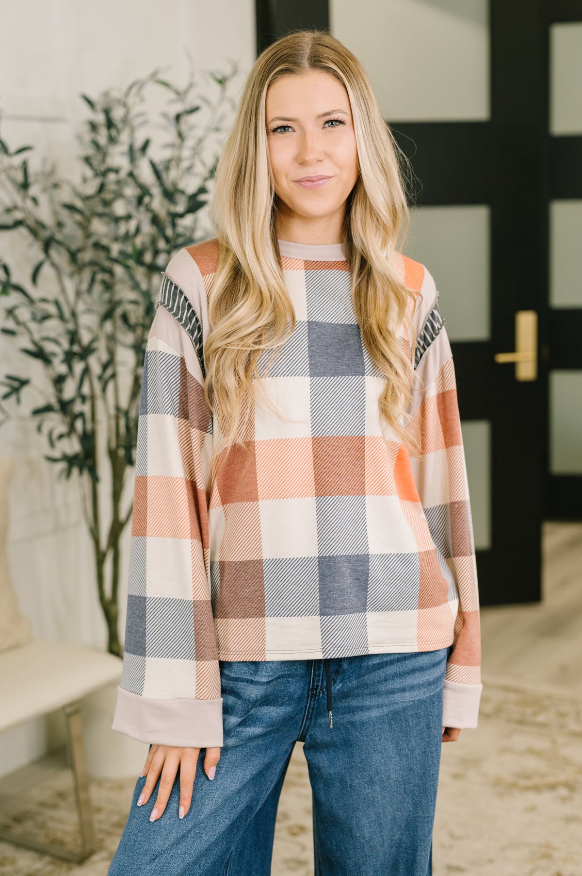 A relaxed casual top in a multi-color plaid design with a banded round neckline and wide sleeves.
