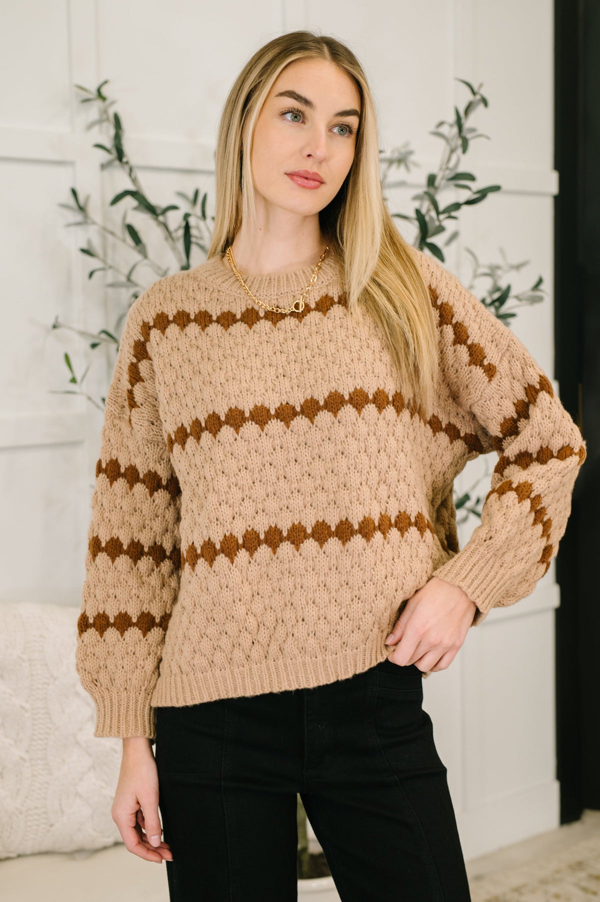 A taupe textured sweater with banded ribbed neckline and cuffs, worn by a model.