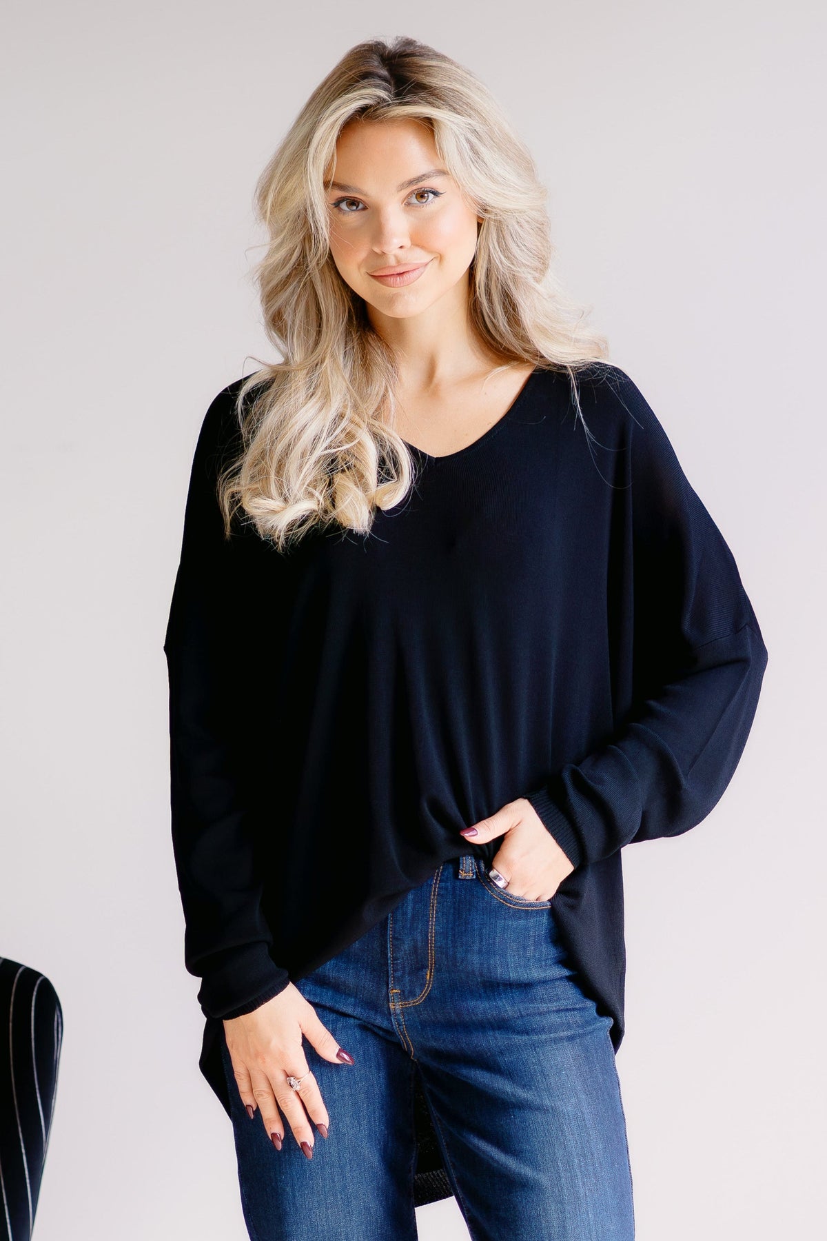 Black loose-fitting sweater with long sleeves and a relaxed silhouette.
