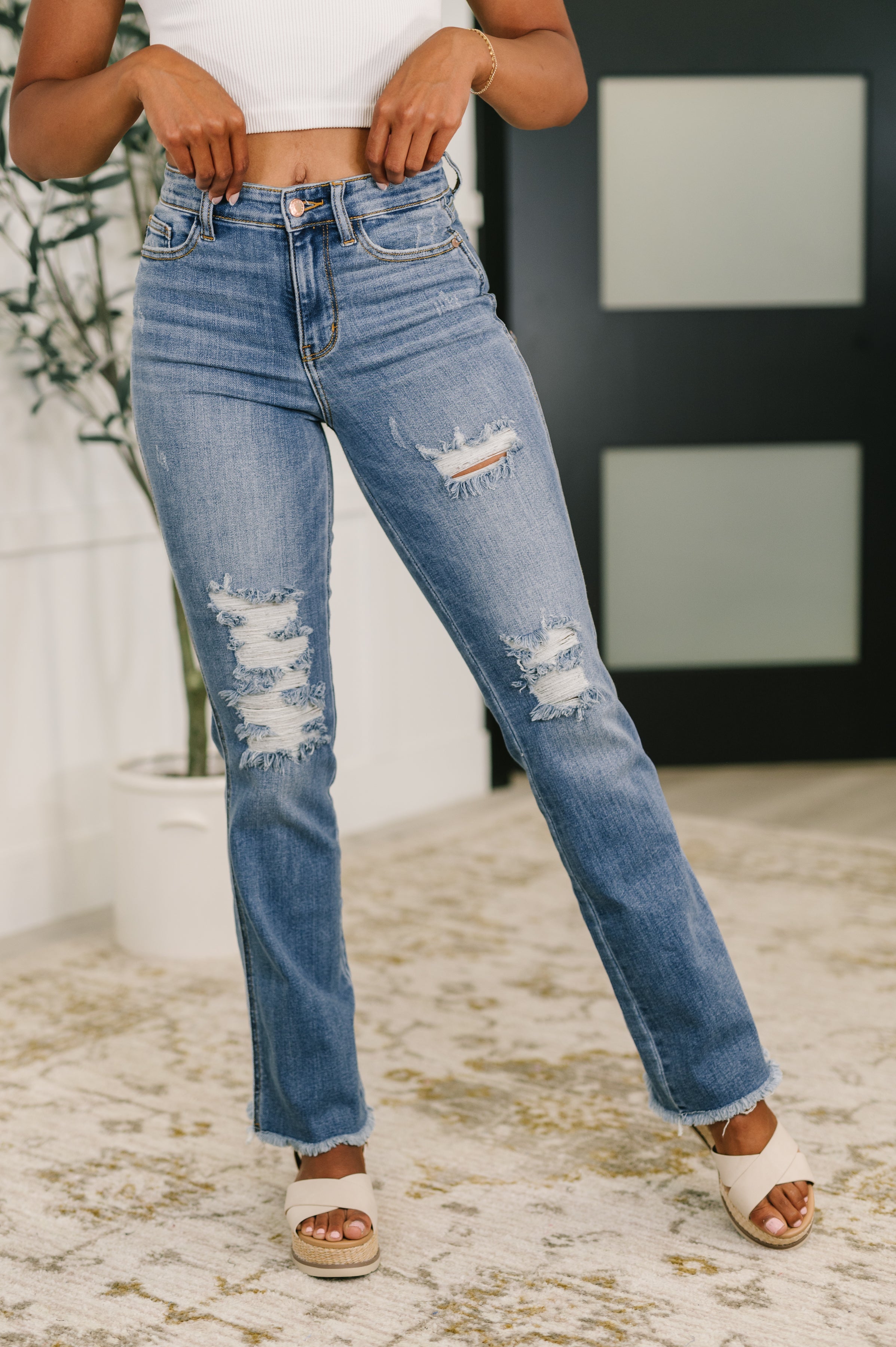 Woman wearing distressed blue jeans with a blurred background