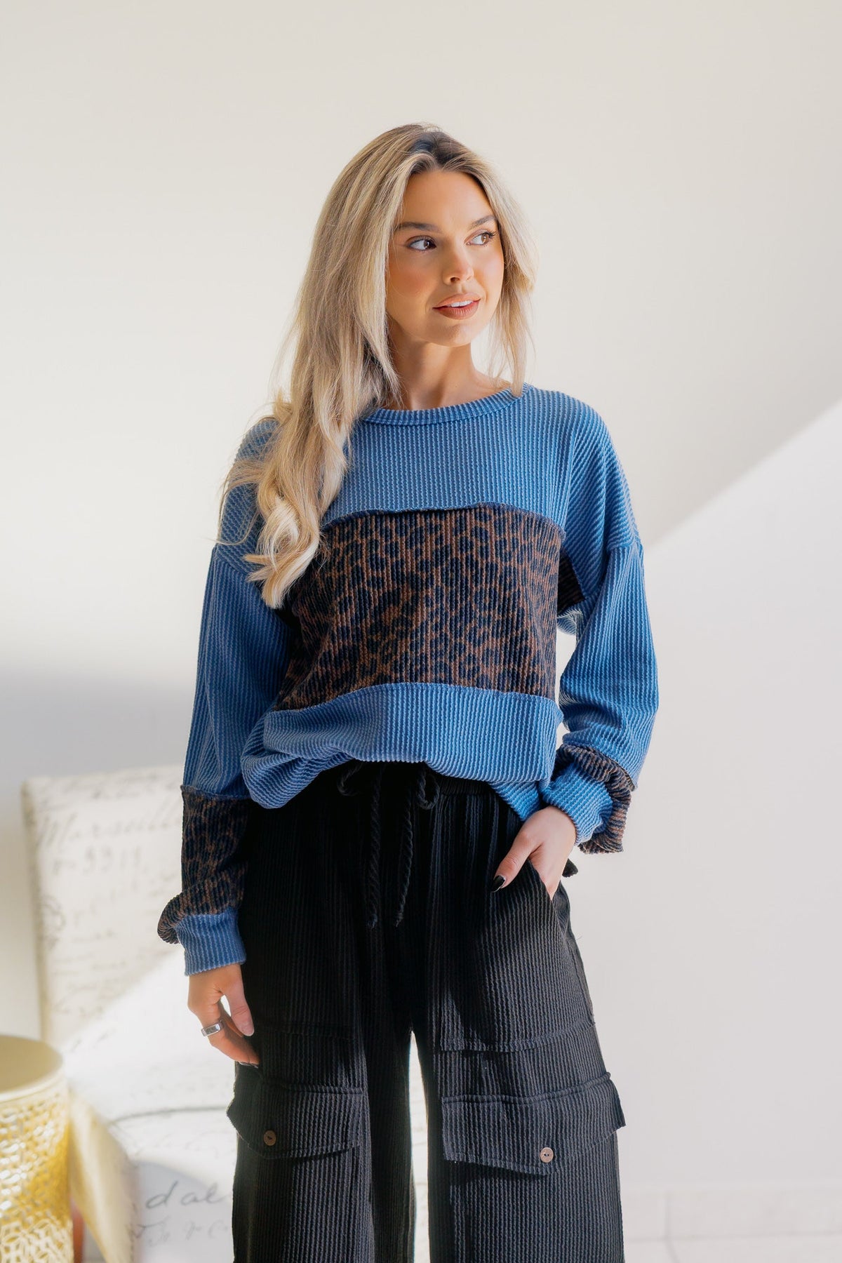 Long-sleeve knit top with blue leopard print and cuffed hems, worn by a model.