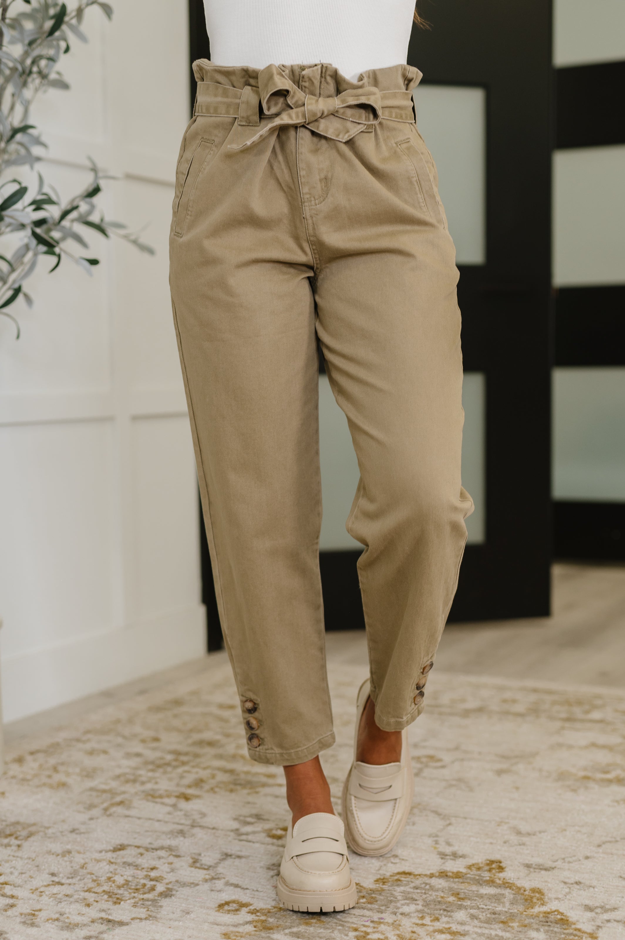 Woman wearing beige paperbag waist pants with a blurred background