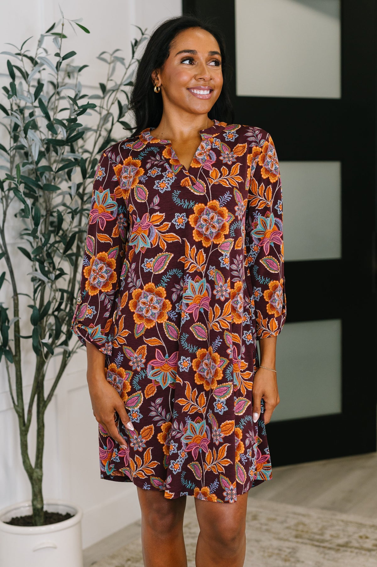Lizzy Long Sleeve Dress in chocolate floral with a V-neckline and 3/4 sleeves featuring a button rolled sleeve tab.