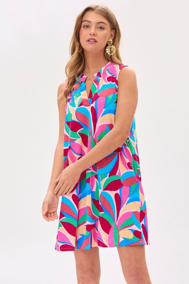 A woman wearing a sleeveless, knee-length, multicolored geometric patterned dress with a mandarin collar.