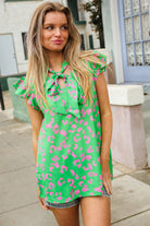 Woman wearing a green shirt blouse top with pink leopard print pattern outdoors.