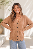 Camel-colored chunky knit cardigan with distressed hem, button-down front, and patch pockets.
