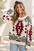 A chunky knit sweater with a bold Aztec pattern in burgundy, teal, mustard, and gray on a cream base.