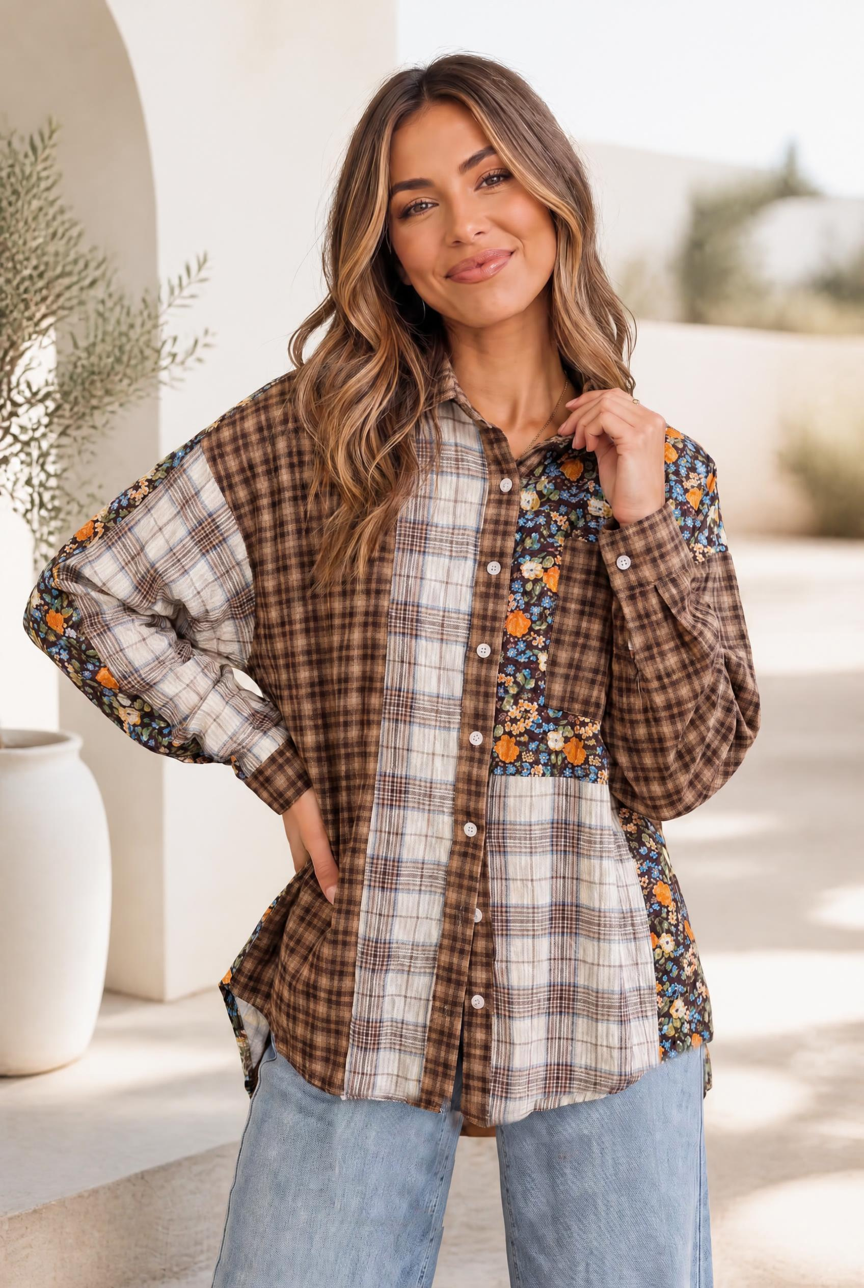 A mixed media button-down shirt with a plaid and floral patchwork design, shown on a model against a cozy backdrop.