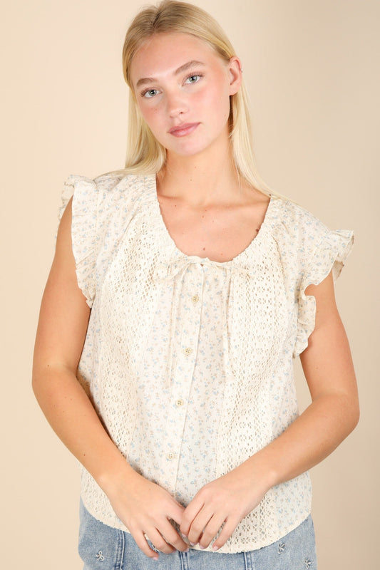Woman wearing a white lace top against a beige background
