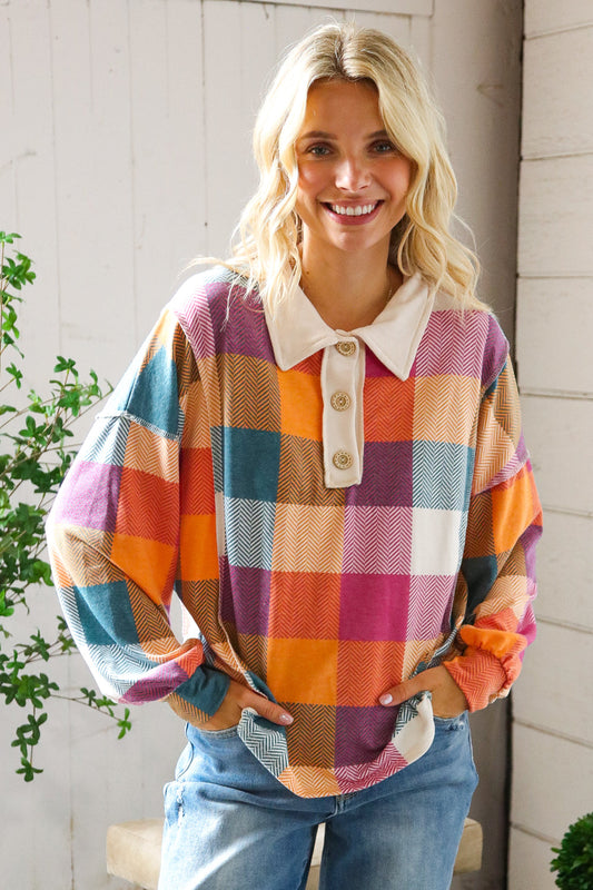 Woman wearing a colorful plaid shirt with a white collar, standing outdoors.