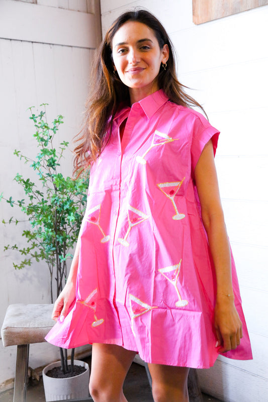 Woman wearing a pink dress with martini glass designs indoors.