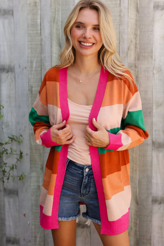 Woman wearing a colorful striped cardigan with a wooden background