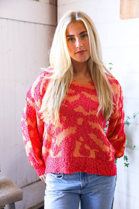 Woman wearing a hot pink and orange patterned sweater indoors