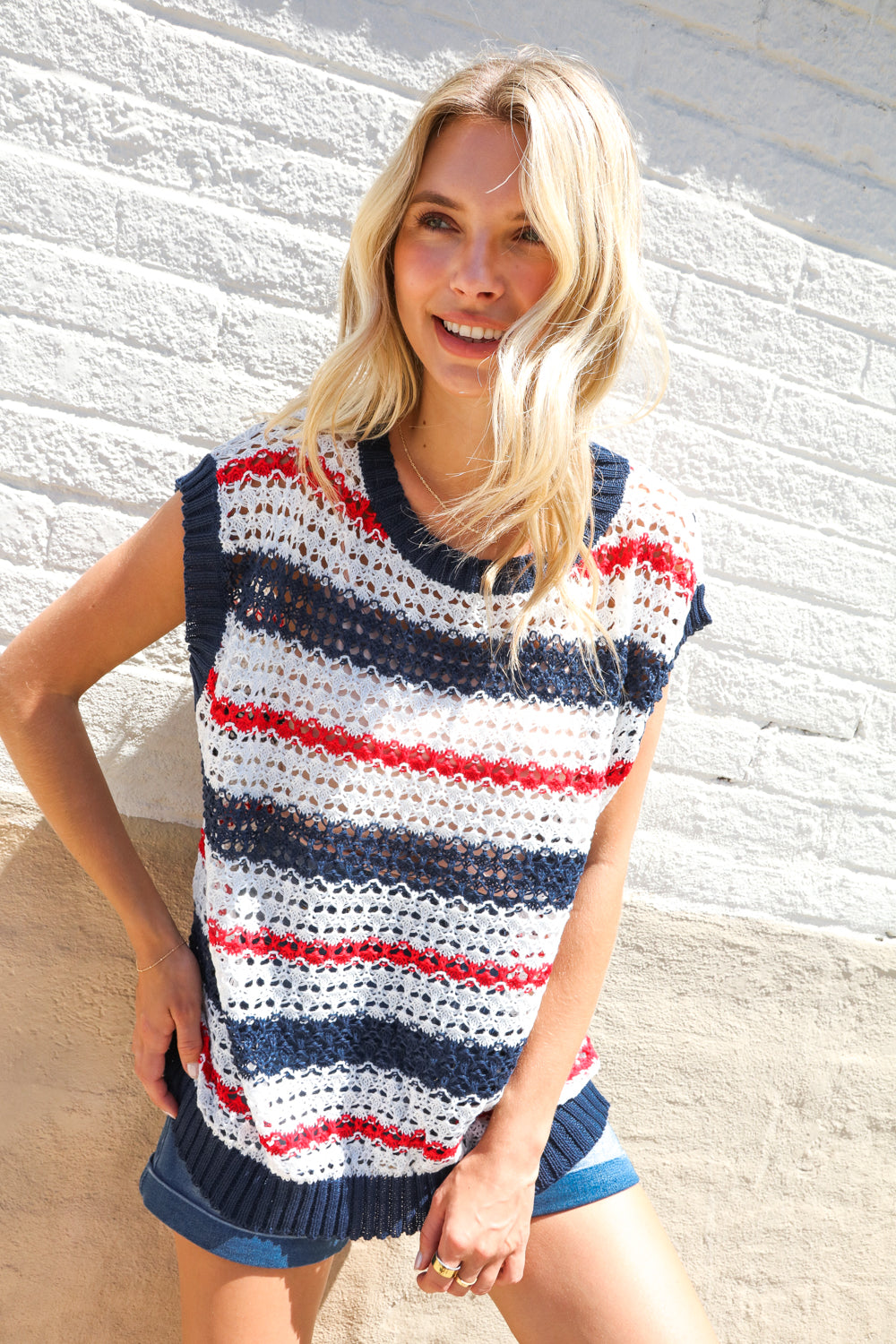 Woman wearing a striped sleeveless top against a white wall