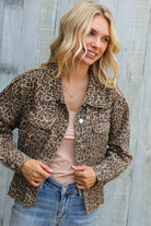 Woman wearing a leopard print jacket against a wooden background