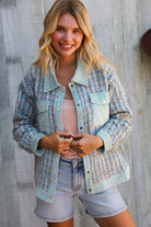 Woman wearing a patterned jacket and shorts against a wooden background