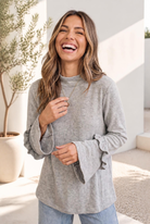 Heather grey knit top with ruffle sleeves and a mock neck neckline.