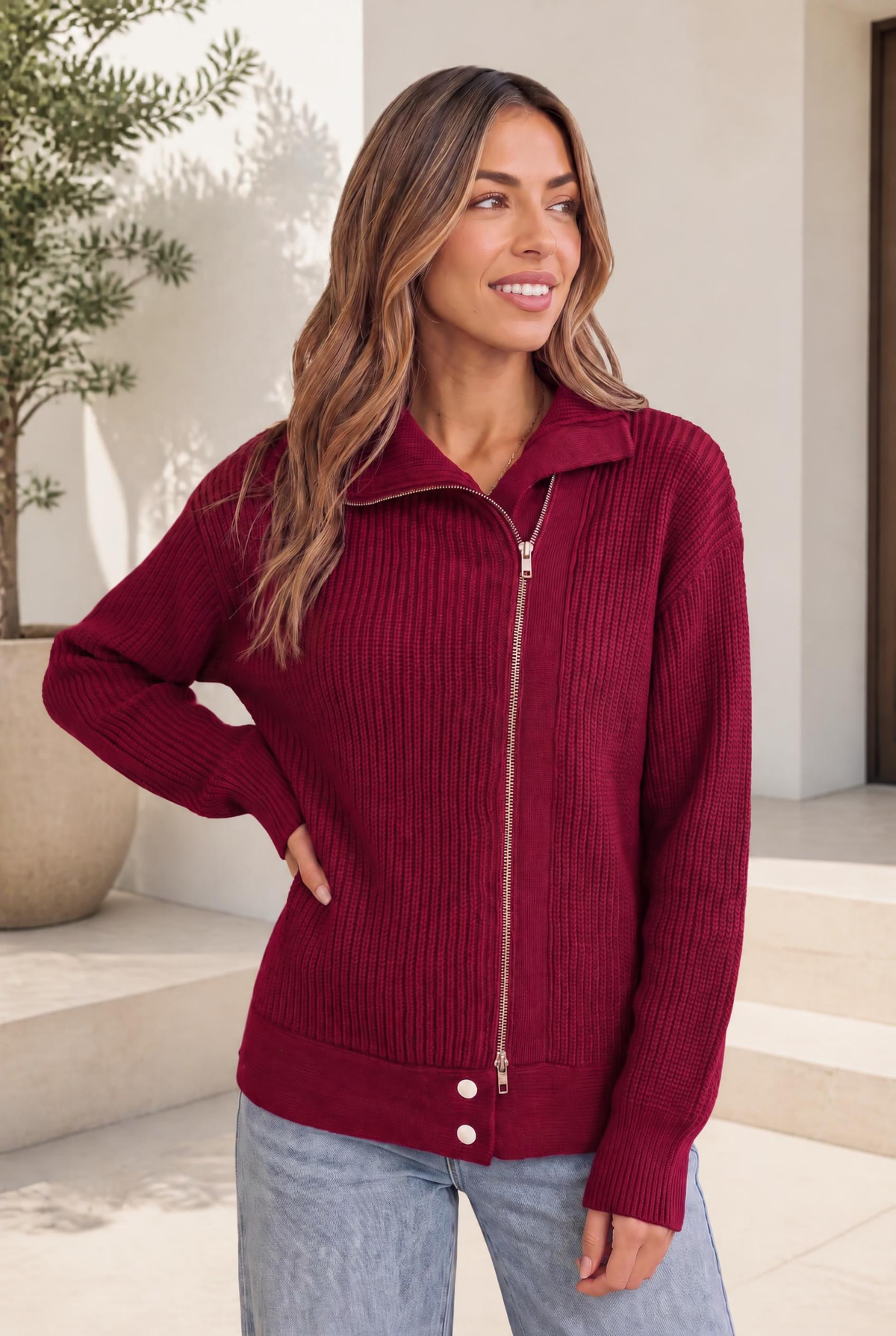 Cranberry ribbed sweater jacket with dual zip closure and high collar worn by a model.