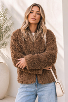 Brown teddy bear faux fur jacket with curly texture and relaxed fit worn by a model.