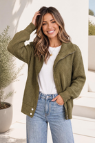 Olive ribbed knit sweater jacket with zip front and snap hem, worn open over a white tee.