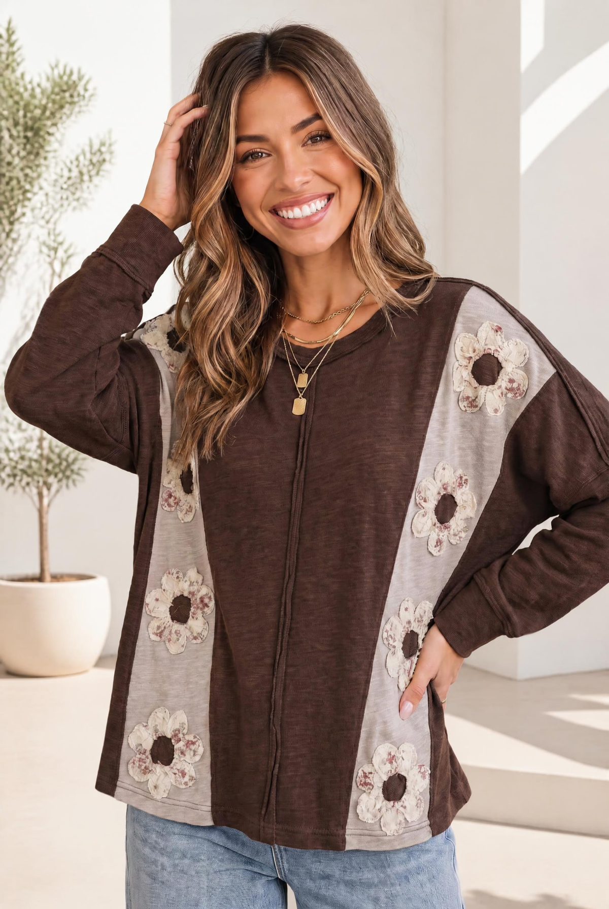 Chocolate brown long sleeve top with floral applique and gray side panels.