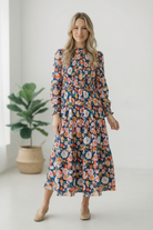 floral midi dress, tiered dress with sleeves, fall wedding guest dress, high neck floral dress, modest long sleeve dress, bouquet print dress, feminine boutique dresses, smocked waist dress