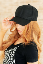Black ball cap with a curved brim and adjustable Velcro strap.