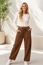 Brown corduroy cargo pants with a wide-leg silhouette and elastic waistband, worn by a person standing outdoors.
