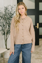 A mocha-colored button down shirt with a collared neckline, drop shoulders, and rolled sleeve cuffs.