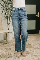A model wearing high-waisted straight-leg jeans in a medium indigo wash.