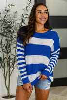 Woman wearing a blue and white striped sweater in an indoor setting