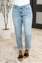 A woman wearing light blue denim boyfriend jeans with a V-front waistband and optional cuffed hem.
