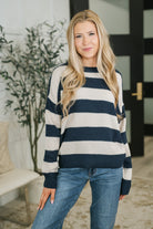 Navy and cream striped sweater with drop shoulder and ribbed cuffs worn by a model.