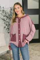 Model wearing a striped button-down hooded top with contrast detailing and patch pockets.
