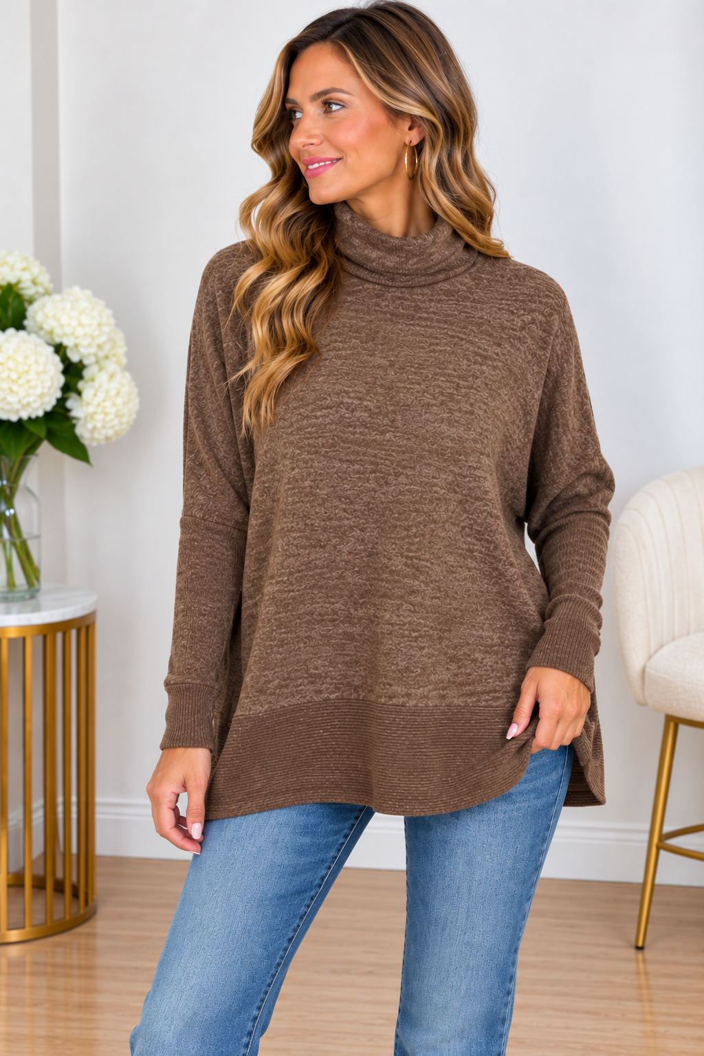 Brown boxy sweater with 3/4 sleeves and side slits, worn by a woman with long hair.