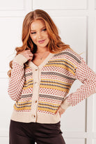 Woman wearing a patterned cardigan against a white background