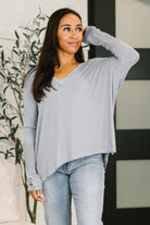 Grey V-neck top with contrast waffle knit sleeves and side slits.