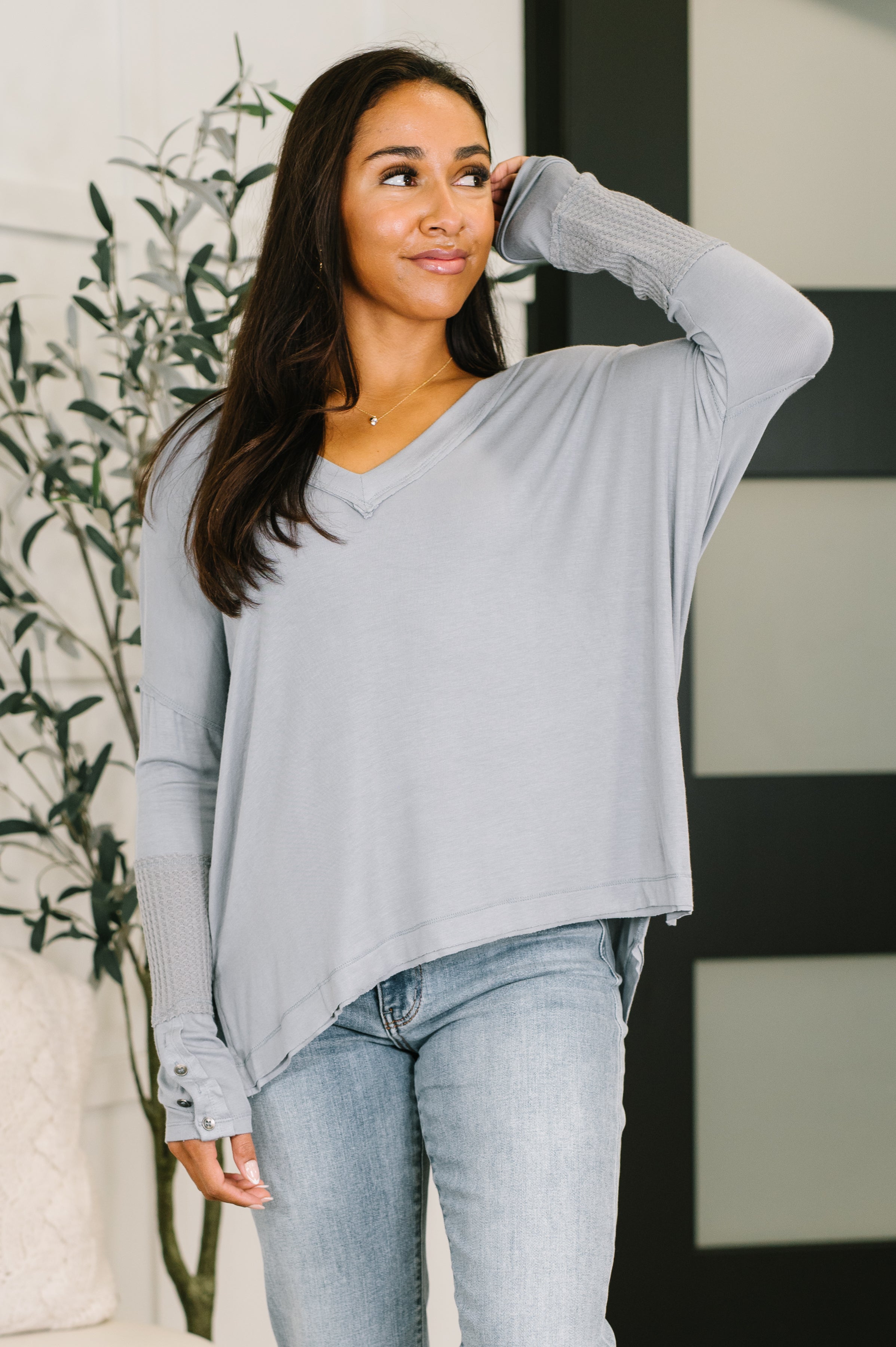 Grey V-neck top with contrast waffle knit sleeves and side slits.