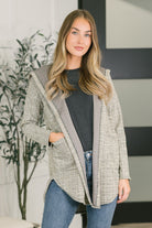 Neutral plaid hooded cardigan with open front, long sleeves, and patch pockets.