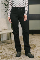 Model wearing black high waist jeans with a classic straight fit and a polka dot top.