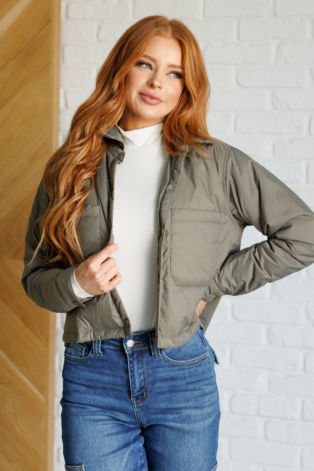 Olive lightweight puffer jacket with snap front, two patch pockets, and a cropped, boxy silhouette.